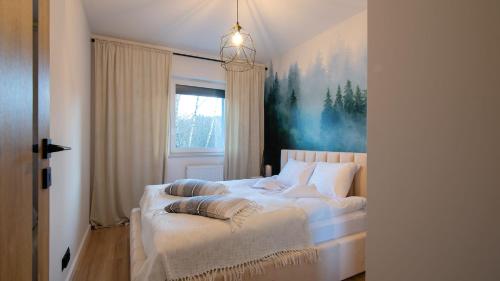 um quarto com uma cama com um quadro na parede em Apartament na Spokojnej em Wisla