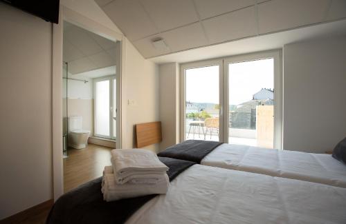 a bedroom with a large bed with towels on it at Pensión Roma in Castroverde