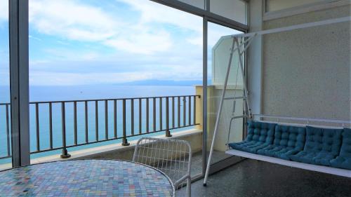 Un balcón con una silla azul y una mesa en Apartamentos Nautilus, en Salou