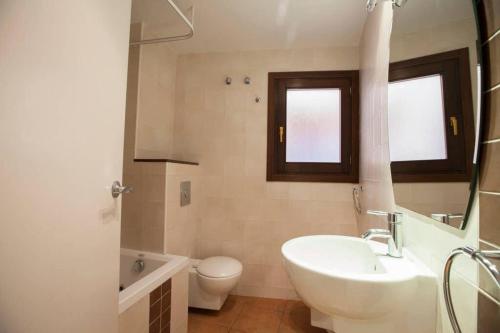 a white bathroom with a sink and a toilet at La Bella Lola Boutique Home in Palamós