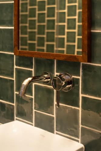 a bathroom sink with a faucet and a mirror at Casa do Lado - Branco de Cal in Vila Nova de Milfontes