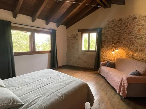 um quarto com uma cama, um sofá e janelas em La Morada de Creta em Aren
