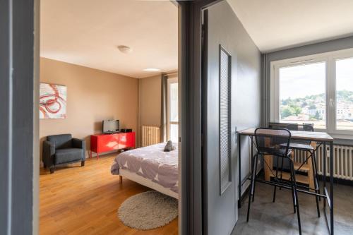 1 dormitorio con cama, escritorio y mesa en Appart'hotel de Montplaisir en Saint-Étienne