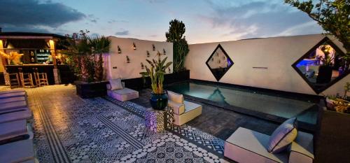 une arrière-cour avec une piscine et des chaises ainsi qu'un bâtiment dans l'établissement Palais-Riad Razala & Spa, à Marrakech