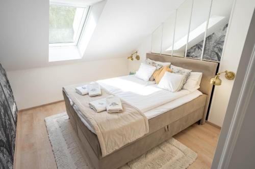a bedroom with a bed with two towels on it at Palmowe Wzgórze Skoszewo - Luksusowe Apartamenty in Skoszewo