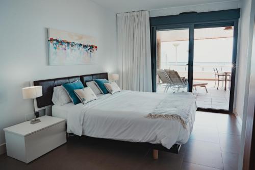 a bedroom with a large bed with a view of the ocean at Apartamentos Calpestabili in Altea