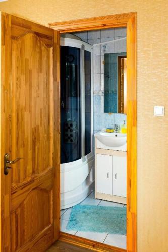- une porte ouverte donnant sur une salle de bains avec lavabo dans l'établissement Anniņas, à Ventspils