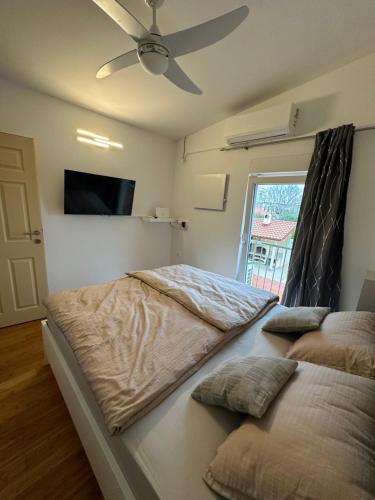 1 dormitorio con 2 camas y ventilador de techo en Holiday house Ina***, en Barbat na Rabu