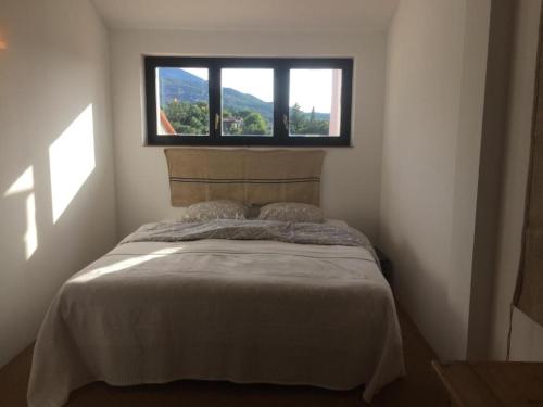 Un dormitorio con una cama y una ventana encima. en Maison Blanche, en Laroque-des-Albères