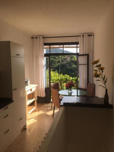 una cucina con un tavolo e una sala da pranzo con una finestra di Maison Blanche a Laroque-des-Albères