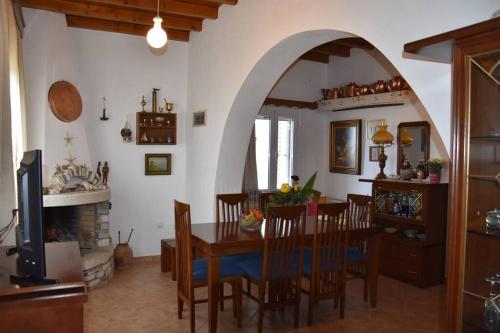 cocina y comedor con mesa y chimenea en Villa with Amazing Sea View, en Moutsoúna