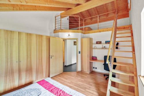 1 dormitorio con litera y escalera en Logement avec vue sur la plaine, en Troistorrents