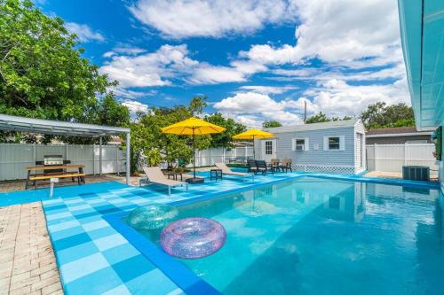 a swimming pool with chairs and umbrellas at Bright 4 Bedrooms with Pool and Game Room near Hard Rock in Hollywood