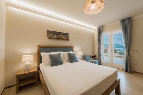 una camera da letto con un grande letto bianco e una finestra di BnB Il Grecale a Lacona