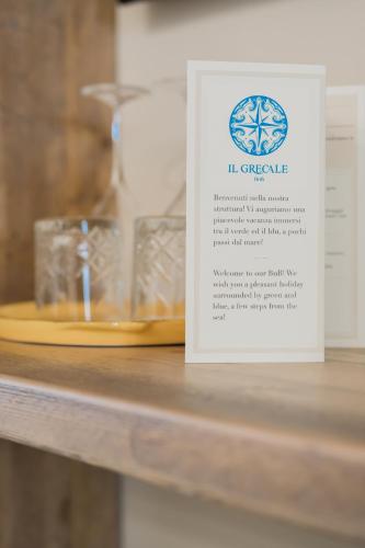 a sign sitting on a shelf with a table at BnB Il Grecale in Lacona