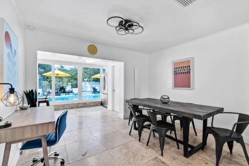 a dining room with a black table and chairs at Bright 4 Bedrooms with Pool and Game Room near Hard Rock in Hollywood
