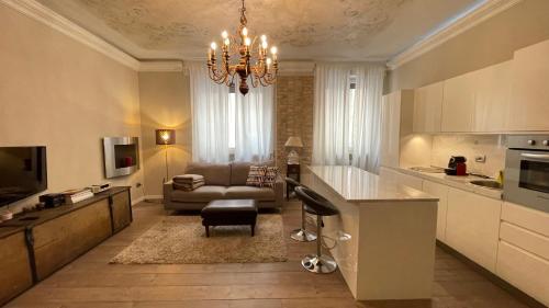 cocina y sala de estar con lámpara de araña en Boadream - Lussuoso appartamento in centro storico, en Parma