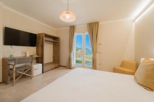 a bedroom with a bed and a desk and a television at BnB Il Grecale in Lacona