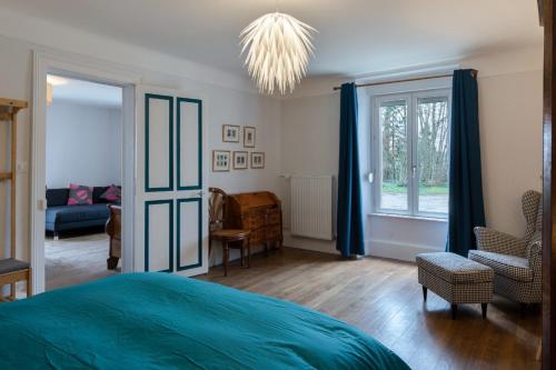 Un dormitorio con una cama azul y una ventana en Château Viéndal proche Vittel et Contrexéville, 