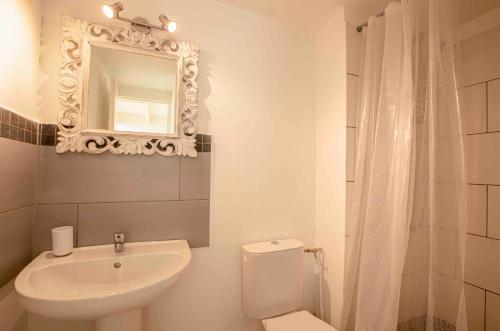une salle de bain avec un lavabo, des toilettes et un miroir dans l'établissement La Maison de la mer, Golfe de saint-tropez, à Gassin