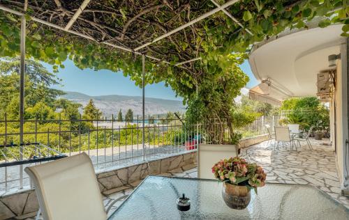 a patio with a glass table and chairs with a view at lux porodicni apartman Ciric in Herceg-Novi