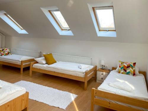 a attic room with three beds and skylights at Tanyacsárda Panzió in Baja