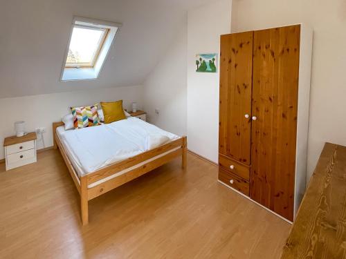 um quarto com uma cama e um armário de madeira em Tanyacsárda Panzió em Baja
