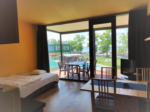 een slaapkamer met een bed, een televisie en een patio bij Soleil Apartmanok Balatonlelle in Balatonlelle