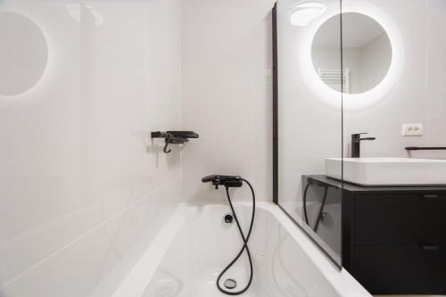 La salle de bains est pourvue d'une baignoire et d'un lavabo. dans l'établissement Chocolate Delight at West Residence, à Oradea