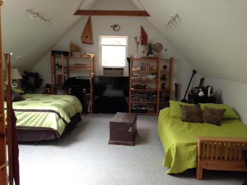 sypialnia na poddaszu z 2 łóżkami i kanapą w obiekcie Inn on the Moraine w mieście Caledon