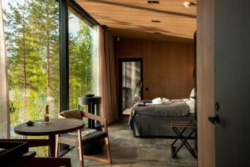 a bedroom with a bed and a table and a window at Kuru Resort in Rantasalmi
