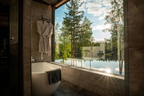 uma casa de banho com banheira e uma grande janela em Kuru Resort em Rantasalmi