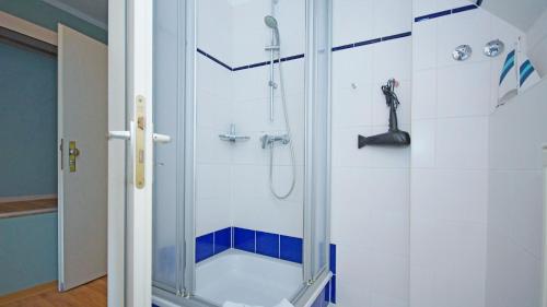 a bathroom with a shower with a glass door at F-1010 Strandhaus Mönchgut Bed&Breakfast DZ 29 strandnah, inkl Frühstück in Lobbe