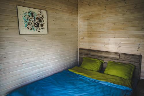 a small bed in a room with wooden walls at Patara cottage, Stepantsminda, Achkhoti, in Stepantsminda