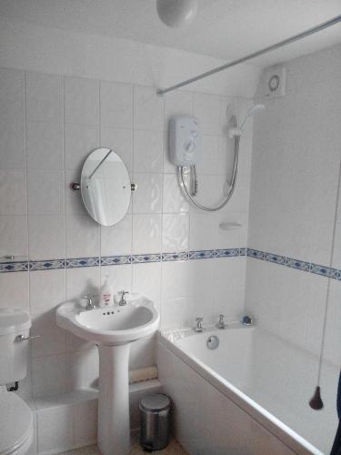 a bathroom with a sink and a toilet and a bath tub at Flo's Cottage self-catering in Newark-on-Trent