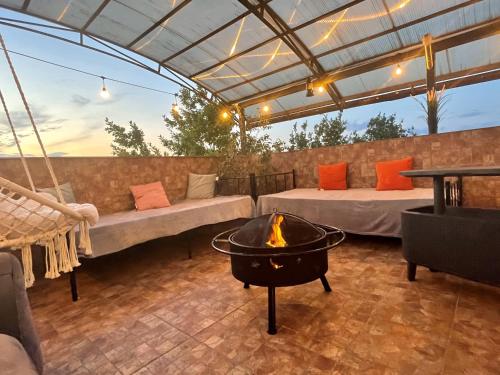 a patio with two beds and a fire pit at Hotel ENZO in Voluntari