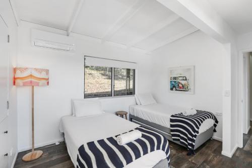 two beds in a room with white walls at Kahala in Point Lookout