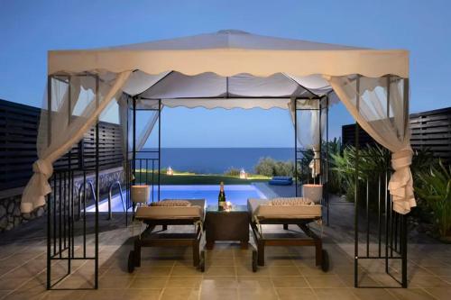 a gazebo with a table and chairs on a patio at Al Mare Villas in Kiotari