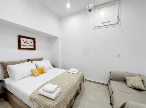 a bedroom with a large white bed and a couch at LOR apparemment in center of Adamas in Adamas