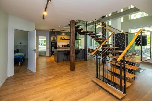 a living room with a staircase and a kitchen at Modern villa with sauna & hot tub in Hiiumaa