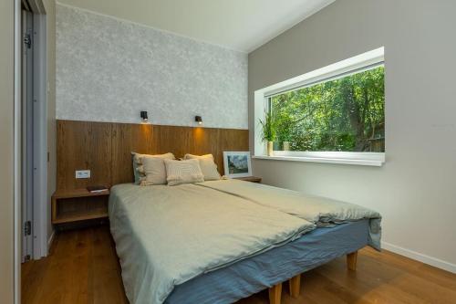 een slaapkamer met een groot bed en een raam bij Modern villa with sauna & hot tub in Hiiumaa