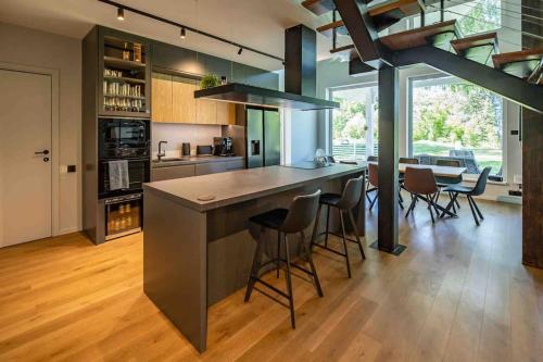 a kitchen with a large island with bar stools at Modern villa with sauna & hot tub in Hiiumaa