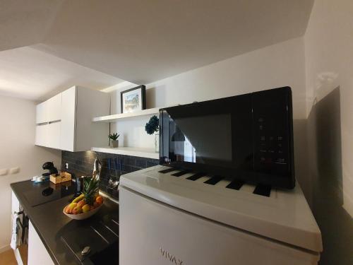 uma cozinha com um micro-ondas em cima de um frigorífico em Korado Studio Apartment em Vrsar