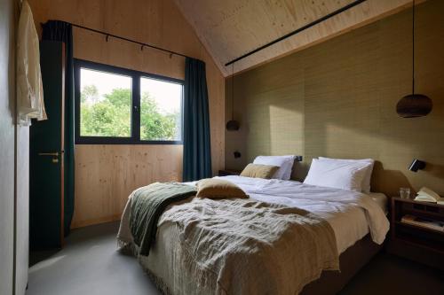 a bedroom with a large bed and a window at Resort de Weelderik in Hengelo