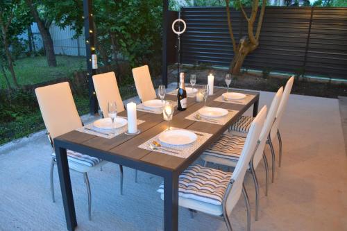 a wooden table with white chairs and candles on it at Family & Relax Loft Lake House in Zagalʼtsy