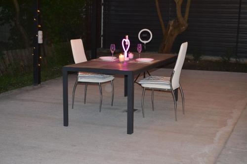 a wooden table with two chairs and two wine glasses at Family & Relax Loft Lake House in Zagalʼtsy