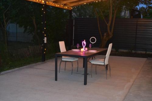 a table with four chairs and a candle on it at Family & Relax Loft Lake House in Zagalʼtsy
