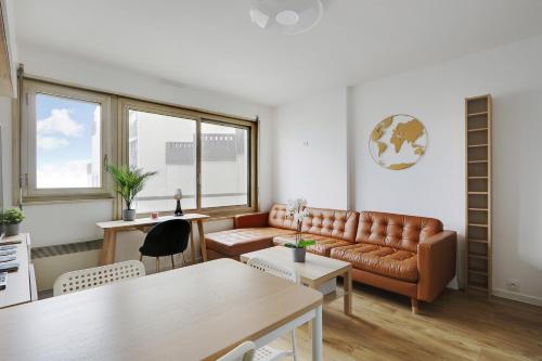 ein Wohnzimmer mit einem Sofa und einem Tisch in der Unterkunft Pick A Flat's Apartment in Montparnasse - Rue Vercingétorix in Paris