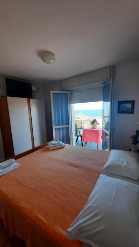 a bedroom with a large bed with a view of the ocean at Albergo Rita in Rimini