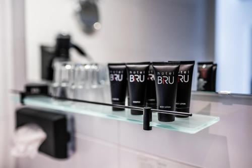 a shelf with hair products on it in a bathroom at Hotel Bru in Bruinisse